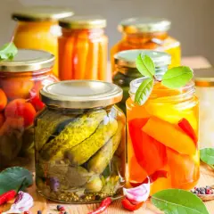 Słoiki z przetworami: ogórki, pomidory, papryka, marchewka, czosnek, chili.