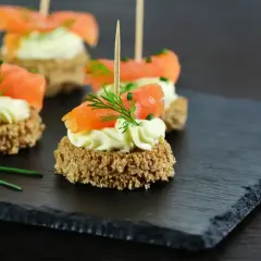 Mini tartinki z łososiem i kremowym serkiem, idealne na efektowną kolację dla znajomych.