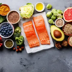 Zdrowe składniki na dietę na wątrobę: łosoś, jagody, awokado, orzechy, warzywa i owoce.