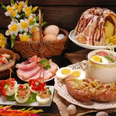 Bogaty stół na śniadanie wielkanocne: babka, biała kiełbasa, jajka faszerowane, chrzan, wędliny i żurek.