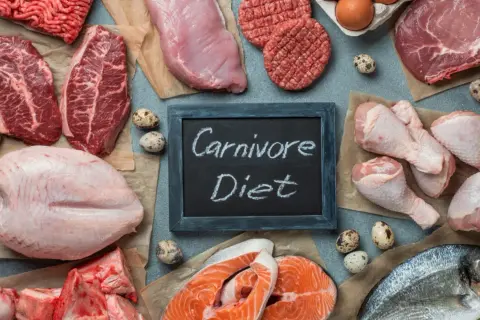 Różnorodne mięsa, ryby i jaja ułożone wokół tabliczki z napisem "Carnivore Diet".