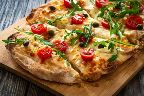 Pyszna pizza z pomidorkami, rukolą i oliwkami, idealna na szybki lunch. Te **pinsy** smakują wyśmienicie!