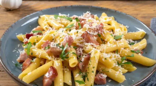 Penne rigate z chrupiącym boczkiem, posypane parmezanem i natką pietruszki. Idealne makaron z boczkiem na szybki obiad.