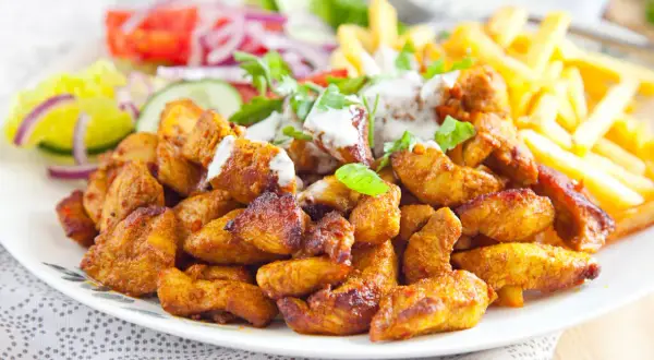 Pyszna shoarma z kurczaka z frytkami i świeżymi warzywami, polana sosem. Idealny posiłek na szybki lunch.