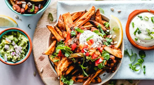 Kolorowe frytki z batatów z salsą, guacamole i śmietaną. Zdrowe jedzenie, które może pomóc w kontroli triglicerydów.