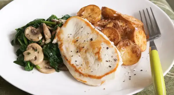 Smażony filet z indyka z pieczonymi ziemniakami i szpinakiem z pieczarkami. Idealne danie, gdy zastanawiasz się, co zrobić z fileta z indyka na szybko.
