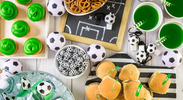 Idealne przekąski na mecz: zielone babeczki, mini burgery, napoje i piłkarskie gadżety.