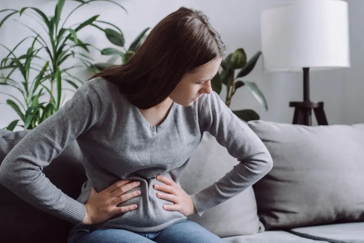 Kobieta z bólem brzucha, być może szukająca ulgi dzięki diecie FODMAP.