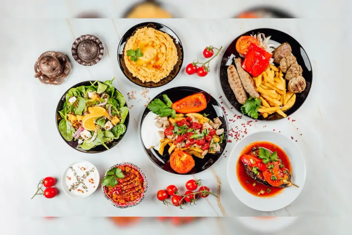 Mnóstwo pyszności na stole! Sałatka, hummus, pieczone warzywa, mięso i frytki – idealna zdrowa kolacja.