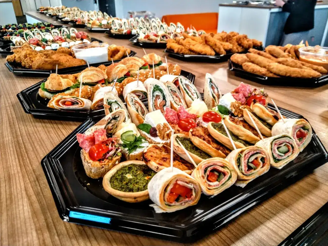 Bogaty śniadanie kontynentalne: rolki z tortilli, mini quiche, kanapeczki, croissanty i chrupiące kurczaki. Idealne na spotkanie!