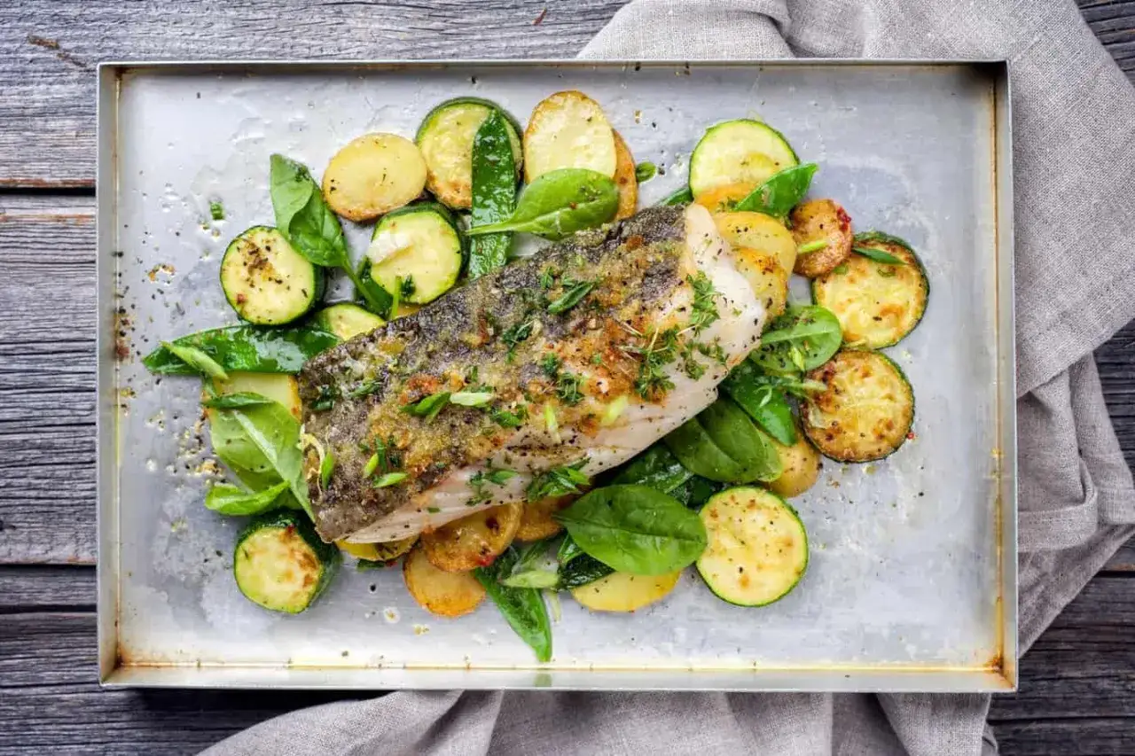 Pieczony filet rybny z ziemniakami, cukinią i szpinakiem. Idealne danie na dietę niskotłuszczową.