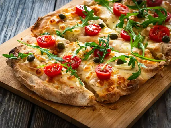 Pyszna pizza z pomidorkami, rukolą i oliwkami, idealna na szybki lunch. Te **pinsy** smakują wyśmienicie!